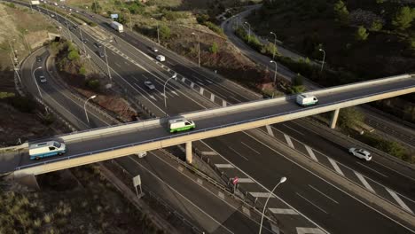 Camper-vans-on-highway-overpass-in-Malaga,-rotation-aerial-drone-view