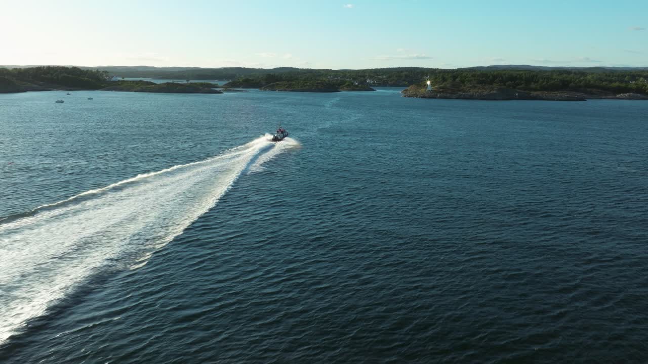 A speedboat smoothly travels through sparkling blue waters, sending white waves behind it. The sun shines brightly over a picturesque coastline dotted with green hills