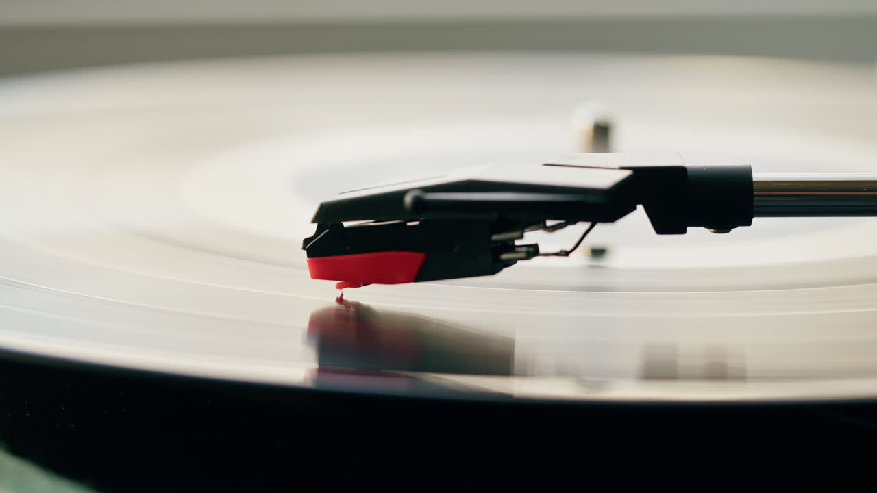 Stilo del giradischi che riproduce un disco in vinile in rotazione.