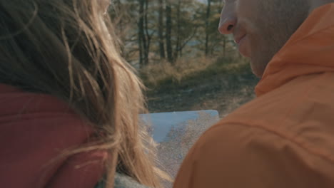 young female and male hikers looking at a map