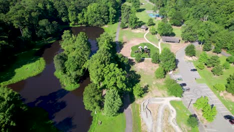 Aerial footage of Boyle Park in Little Rock Arkansas. Camera flies over one of the ponds inside the park. You can see the parking lot and a playground as well
