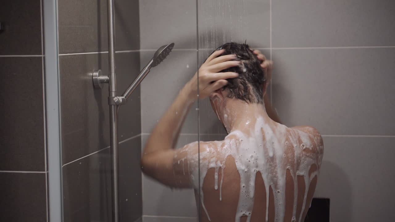 hombre bañándose y lavando el cabello