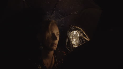 mysterious fantasy woman holding glowing lantern up to face in the darkness of night (cinematic fantasy)