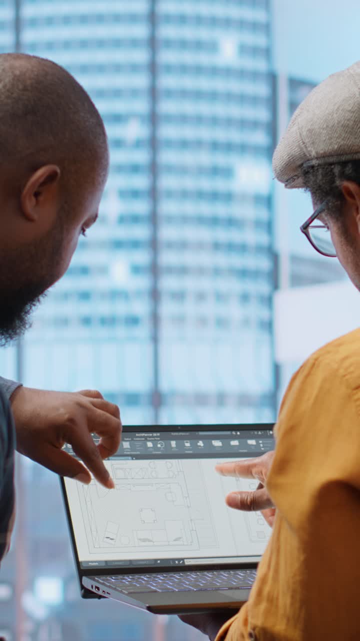 Architects Discussing Building Plans on Laptop in Modern Office