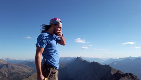 Hiker-victoriously-drinking-beer-on-peak-at-Rocky-Mountain-range-Kananaskis-Alberta-British-Columbia-border-Canada