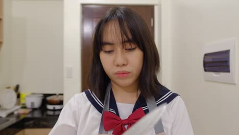 close-up portrait of a young girl wearing apron at the kitchen home