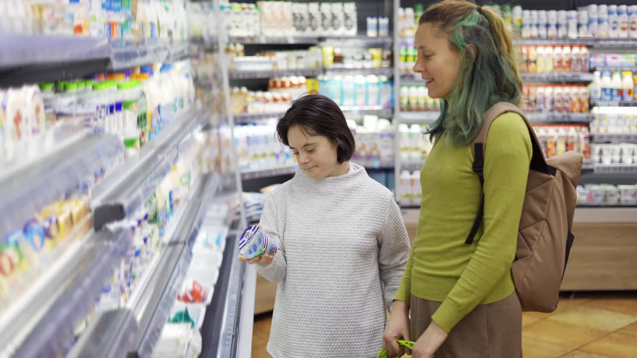 다운 증후군의 소녀가 슈퍼마켓에서 어머니와 함께