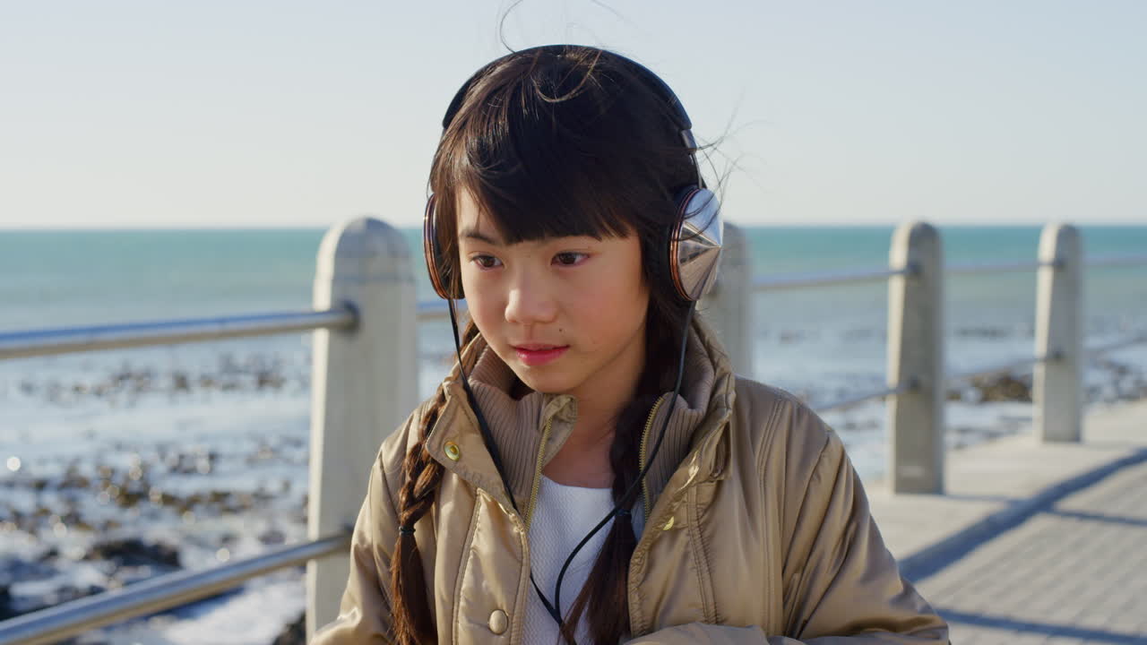 여행, 작은 소녀와 해변에서 헤드폰 음악