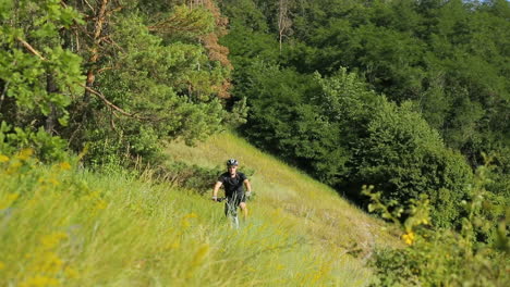 man riding on bicycle. young man riding on bicycle through deep grass