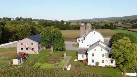 Aerial-orbit-of-Amish-farm-and-buildings,-barn,-silos,-manicured-gardens-in-Lancaster-County,-Pennsylvania-USA