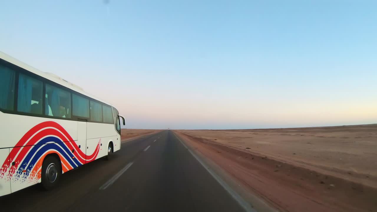 un solo autobús conduciendo por la carretera en el desierto de egipto al amanecer, concepto de vacaciones de viaje