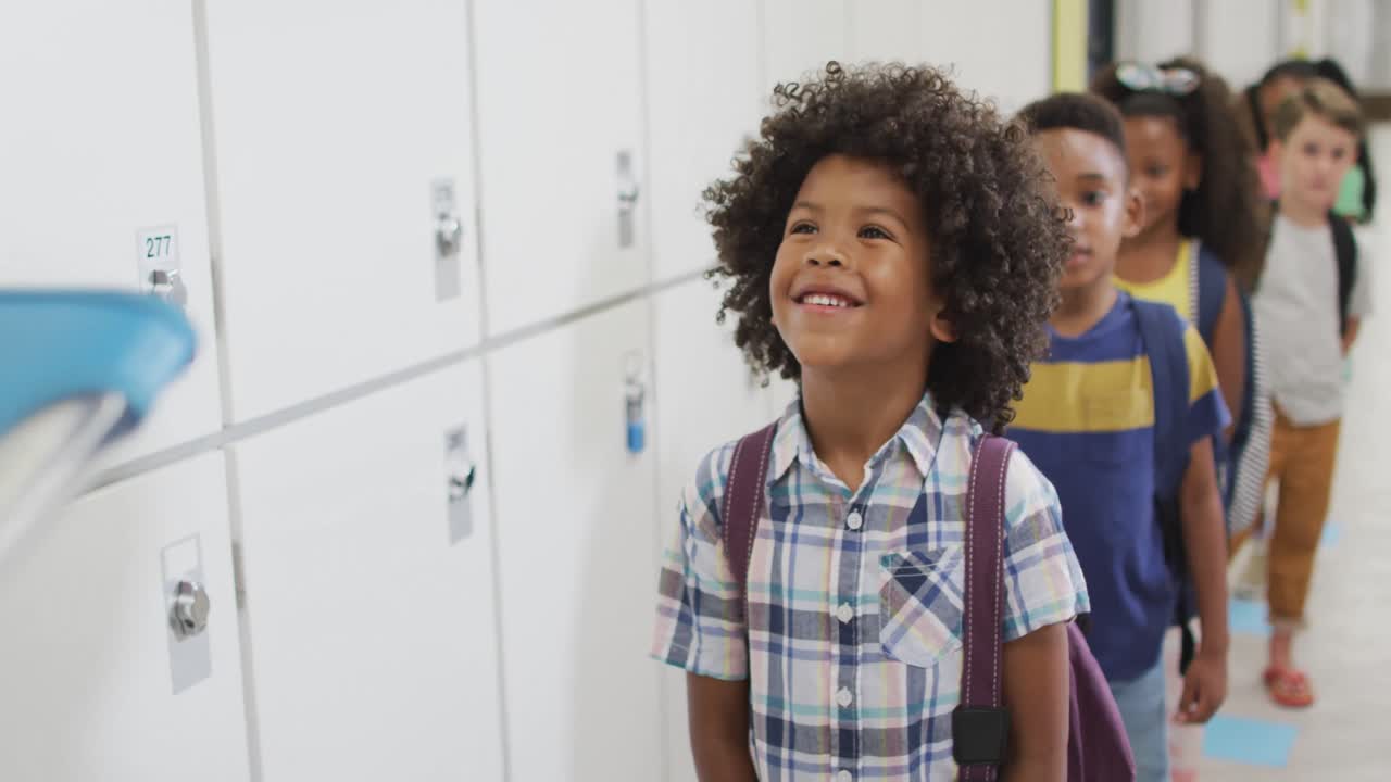 Video of happy african american pupil smiling to caucasian female teacher before lessons