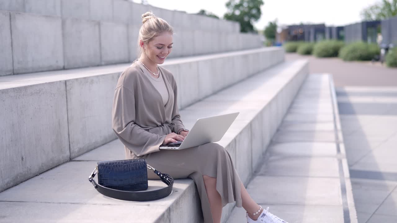 женщина работает на ноутбуке на улице на ступеньках