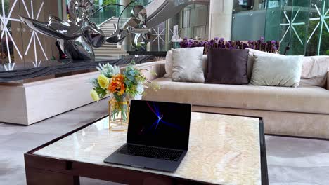 macbook con protector de pantalla en una mesa de mármol en una lujosa mansión con ventanas pegadas
