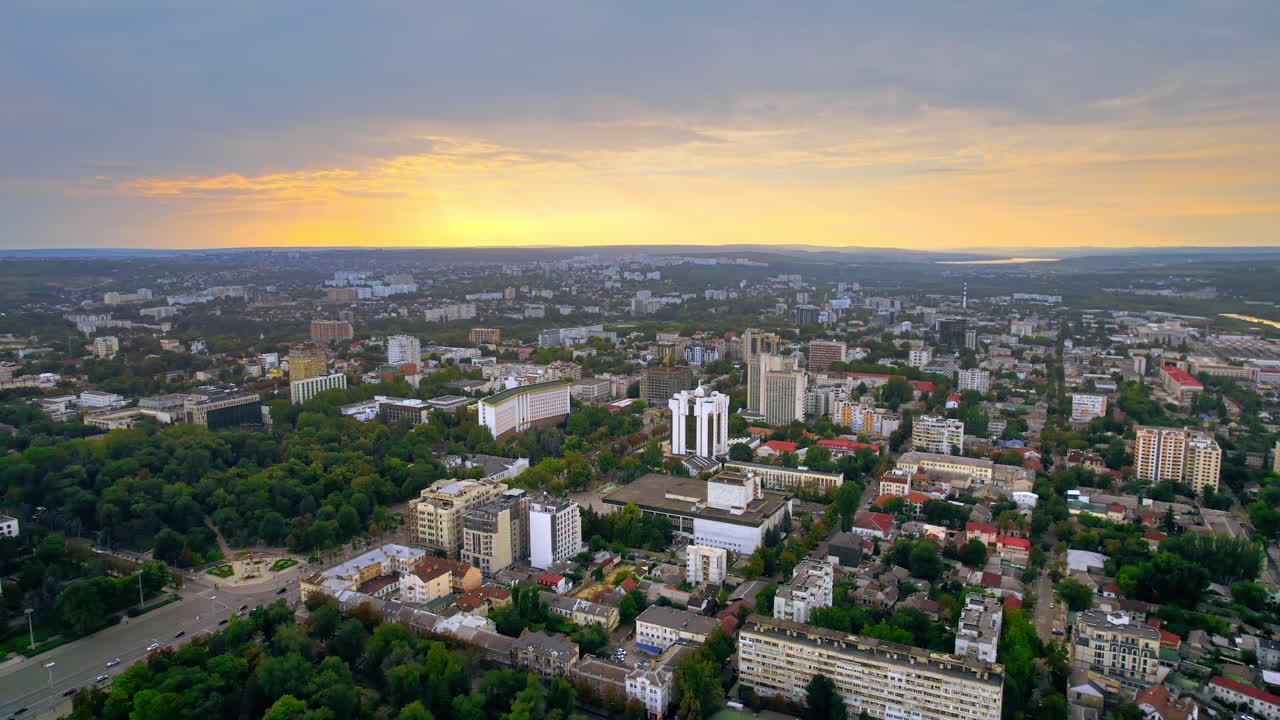 Aerial drone view of Chisinau at sunset, Moldova. View of city centre with multiple buildings, roads, lush greenery