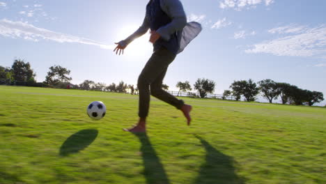 Cuatro-Jóvenes-Jugando-Al-Fútbol-En-Un-Parque-Al-Atardecer