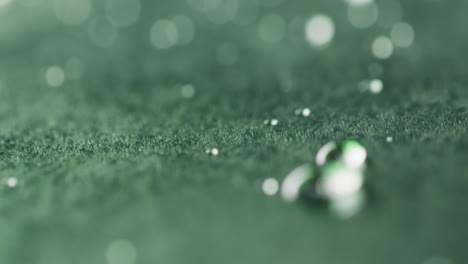 micro video of close up of water drops with copy space on green background
