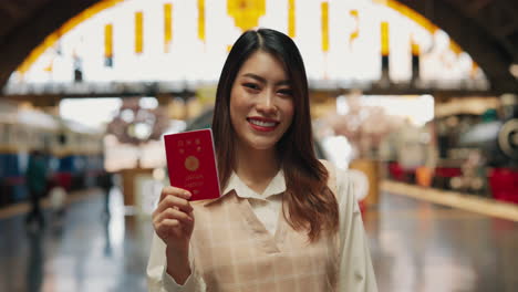 woman holding a japanese passport at a train station