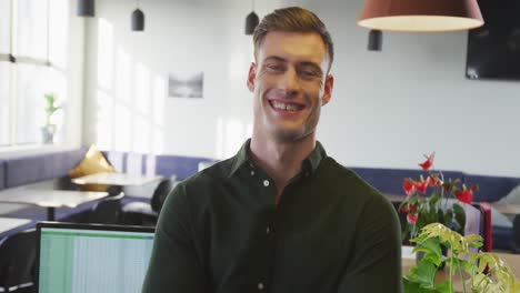 Portrait-of-happy-caucasian-businessman-looking-at-camera-at-office