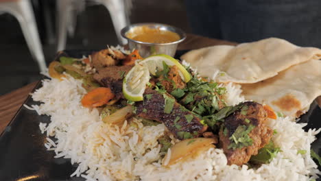 fork takes a bite of beef kabob over rice and vegetables, slider slow motion close up 4k