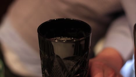 bartender making a cocktail and adding ice in the end. cocktail creation.