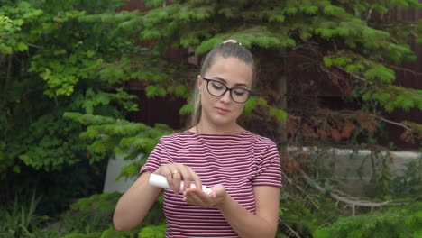 a girl with glasses holds a capsule in her hand and takes out vitamins. maintaining immunity. healthy lifestyle.