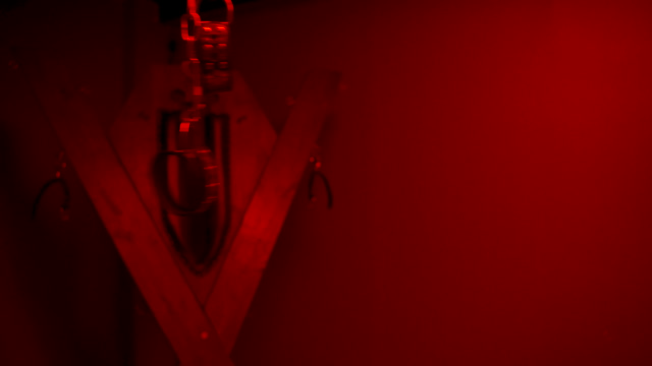equipo de bondage en una habitación roja