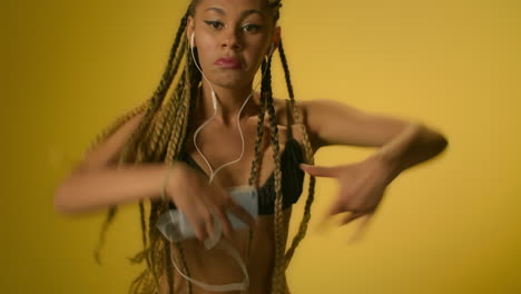african american woman listening mobile music in heaadphone and dancing hip hop