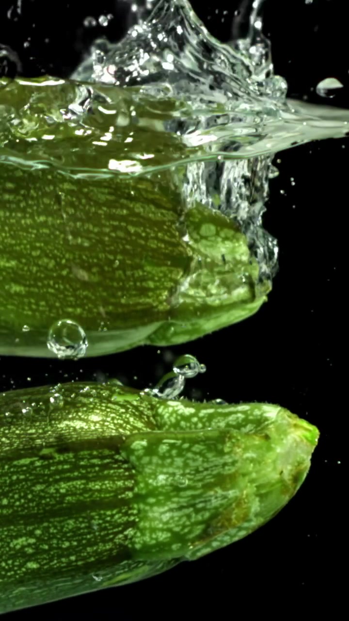 Zucchine Verdi Fresche che Cadono nell'Acqua con Schizzi