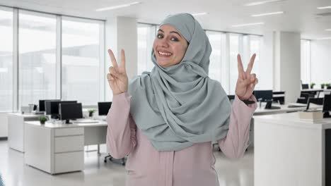 happy muslim businesswoman showing victory sign