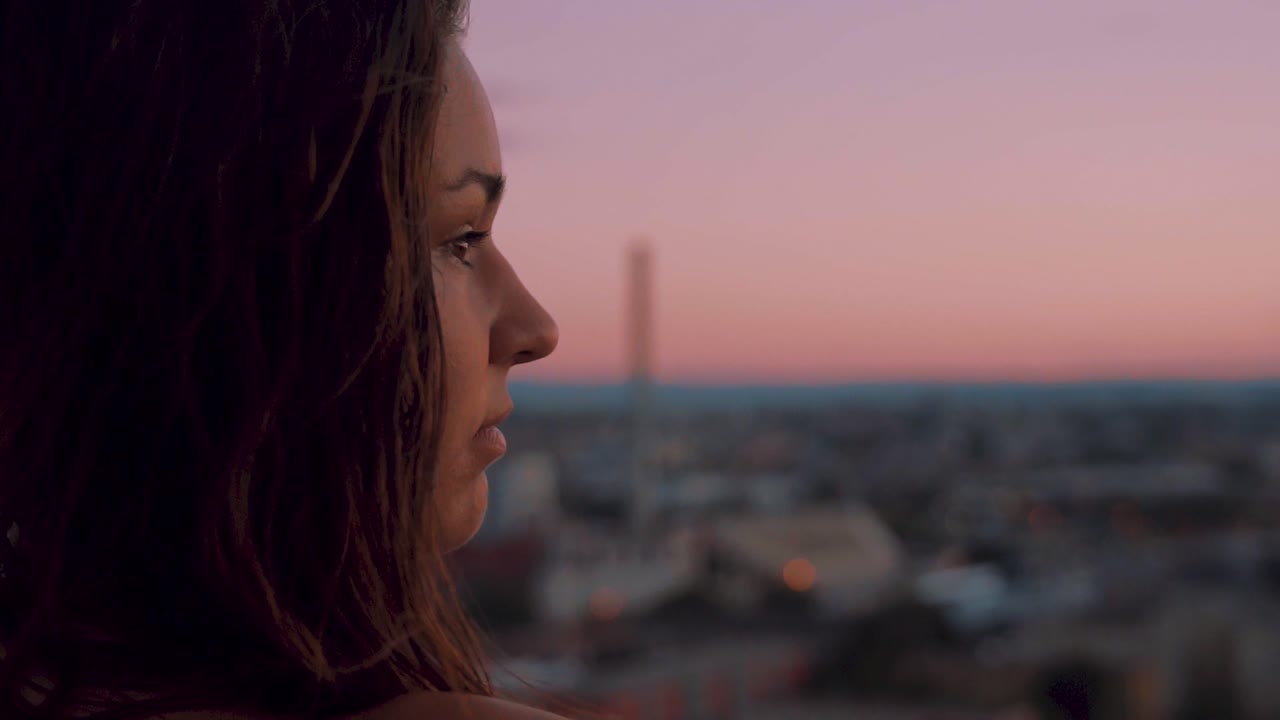 Dreamy Slow Motion of Young Female Watching Twilight Skyline Above European City