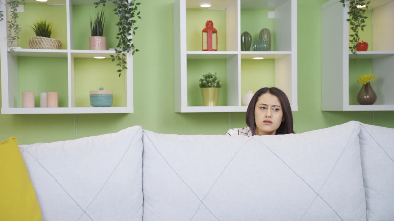 공황과 두려움을 느끼는 젊은 여성은 집에서 힘든 시간을 보내고 있습니다.