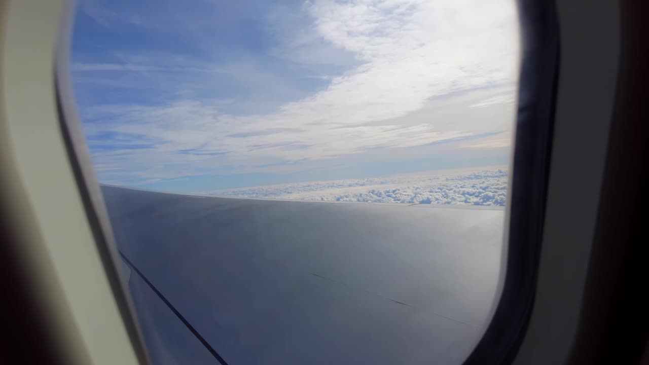 태양의 반사와 함께 구름의 침대 위의 비행기 창을 통해 멋진 하늘