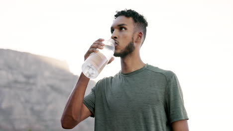 mexican man, drinking water after running in city