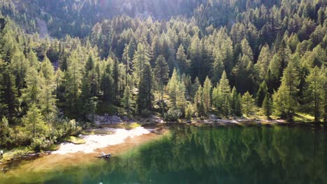 Volando-Sobre-El-Lago-Con-árboles-En-Los-Dolomitas-Con-Nombre-De-Ubicación-De-Drones:-Puntleider-See