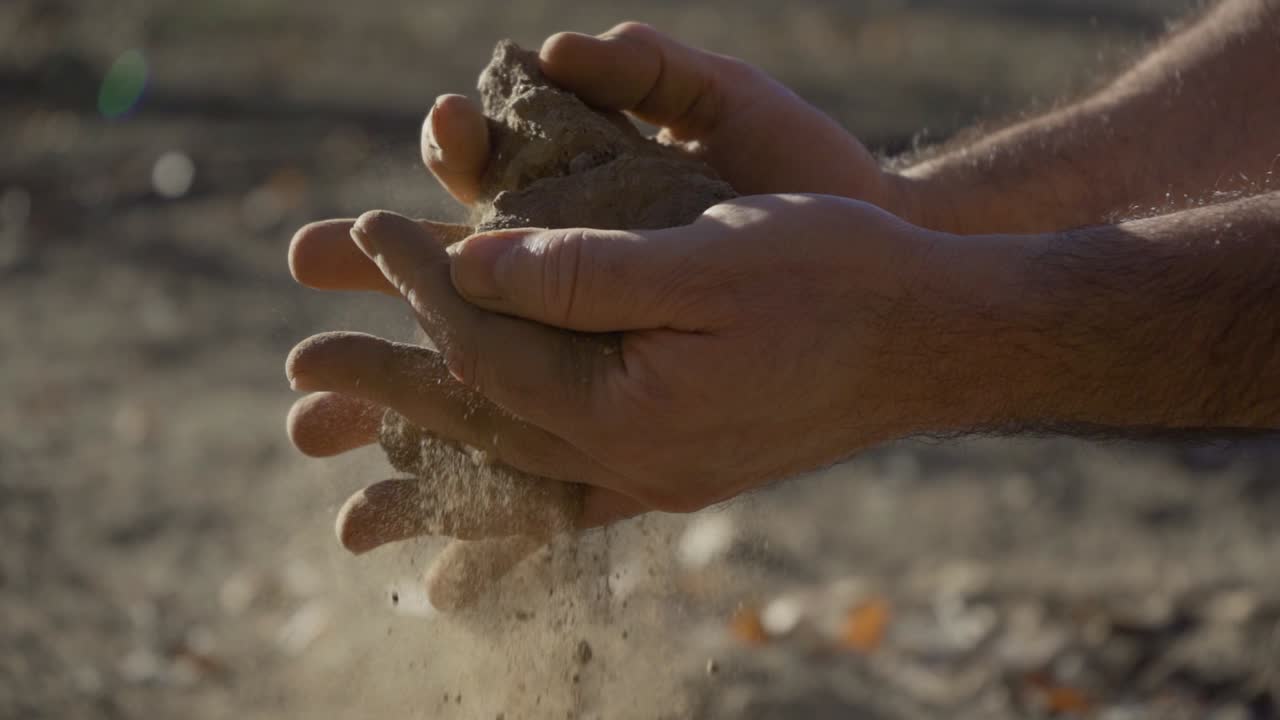Close-up of a Man's Hands Crumbling Soil
