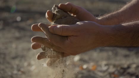 close-up of a man's hands crumbling soil