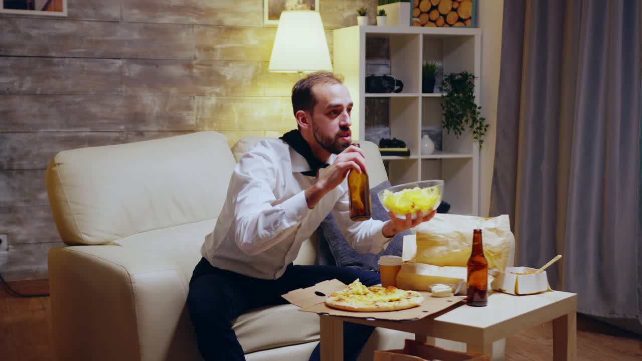 Tired and excited entrepreneur with tie eating chips