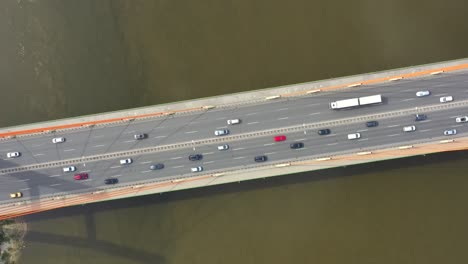 Car-driving-on-highway-bridge-and-road-intersection-in-modern-city-aerial-view