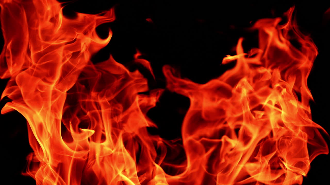 Dangerous red flames moving to the sides close up. Hot fire burning at night.