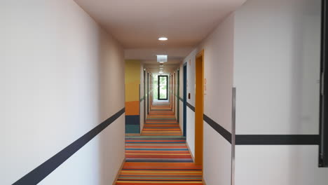 a colorful hotel hallway with doors and bright lighting