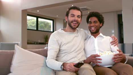 homosexual couple men eating popcorn together