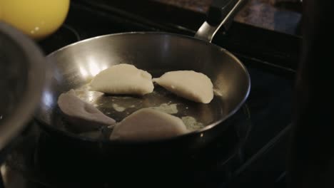 canada - chef putting delicious dumplings in stainless pan for cooking - closeup shot