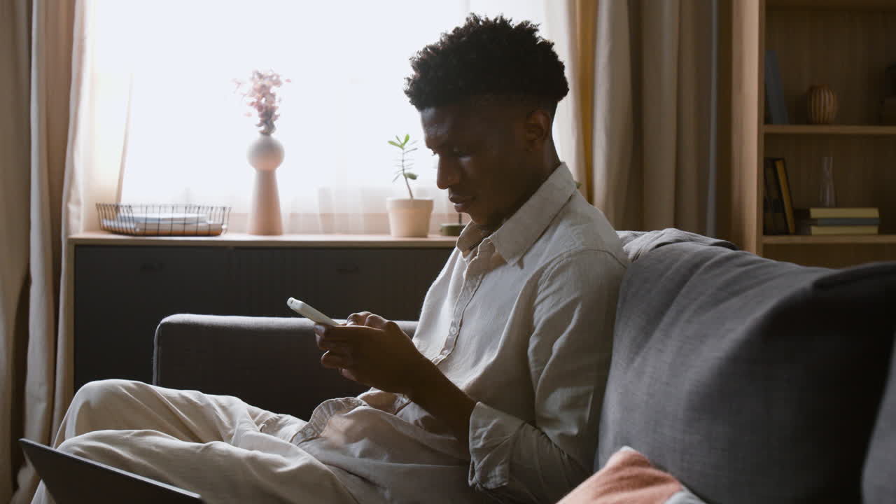 Man using phone on couch