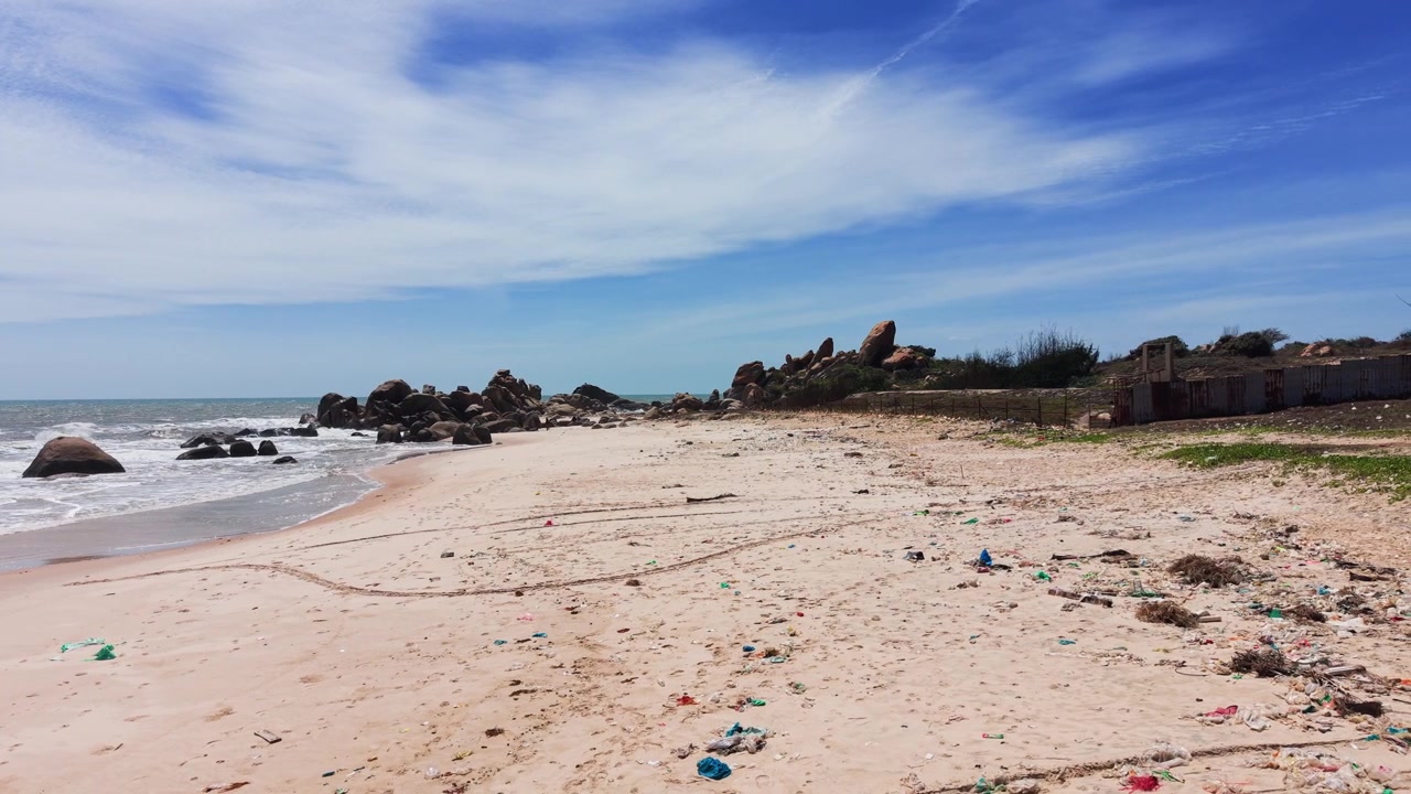 Vista de playa en Tan Thanh, Ham Thuan Nam, Binh Thuan, Vietnam, al mediodía con rocas y olas