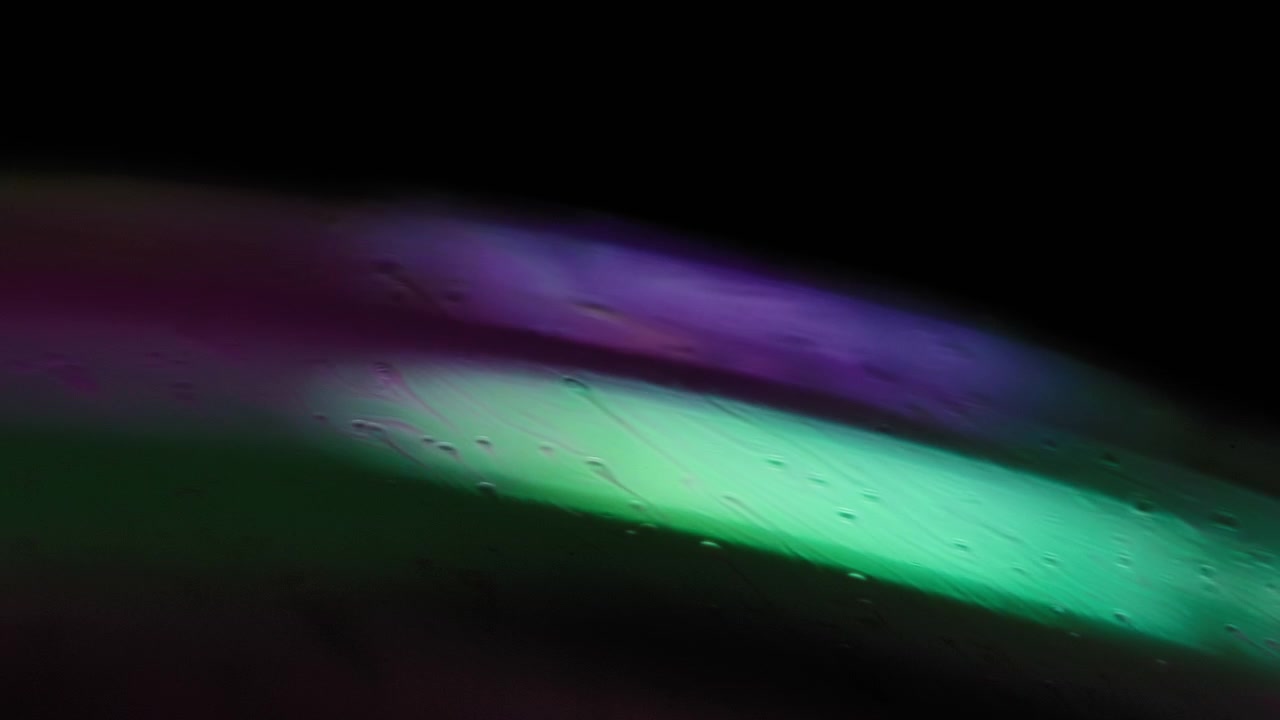 Green and purple colored fluid in motion