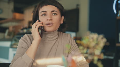 retrato de una mujer que tiene una llamada en una cafetería