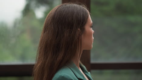 close up portrait of a young woman with long brown hair looking away.