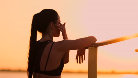 El-Tema-Mujer-Deporte-Y-Salud.-Hermosa-Mujer-Caucásica-Con-El-Pelo-Largo-Y-Rizado-Posando-En-Un-Campo-De-Deportes-Al-Aire-Libre-Sosteniendo-Hor.-El-Tema-Mujer-Deporte-Y-Salud