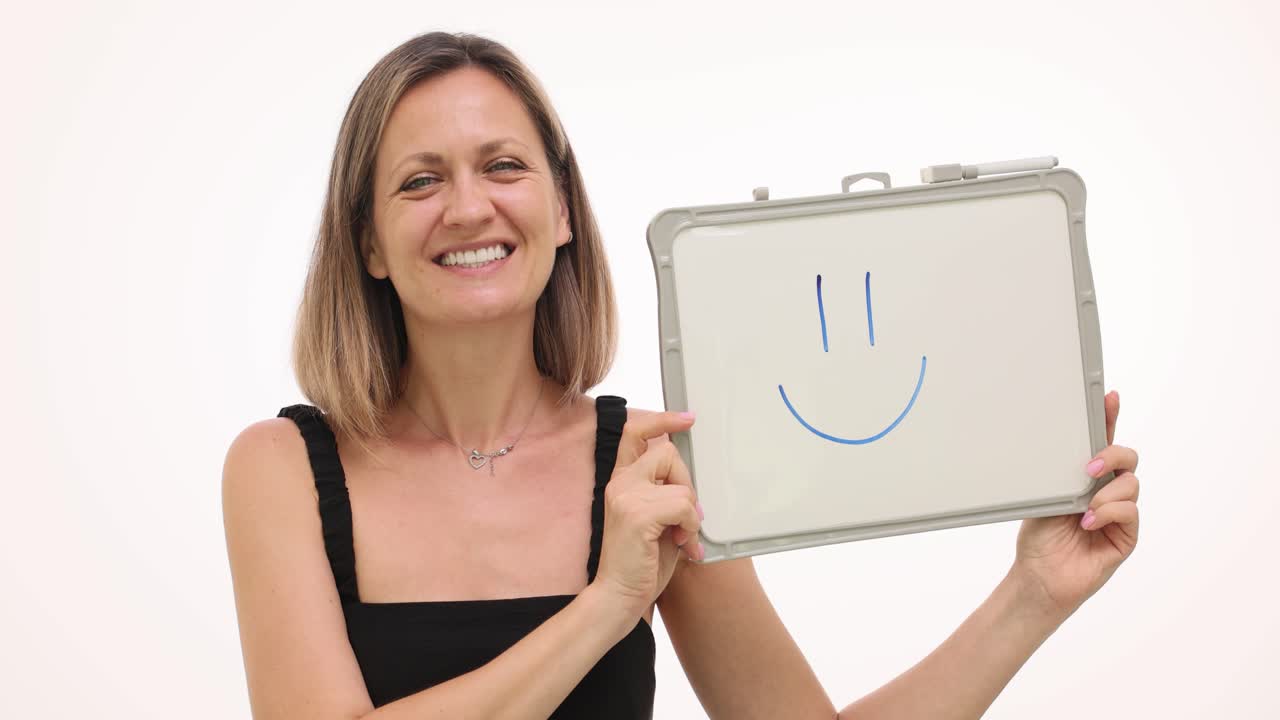 Woman holding whiteboard with smiley face